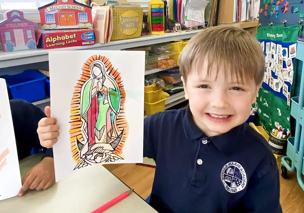 Young student with a coloring page of Our Lady of Guadalupe