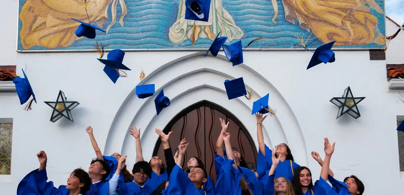 Recent graduates throwing their caps